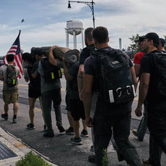 GORUCK team carrying a log and American flag during outdoor rucking event