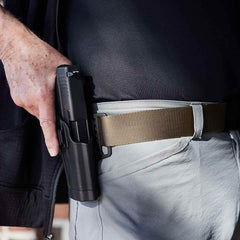 Tactical coyote belt from GORUCK holding a holstered firearm on a person's waist