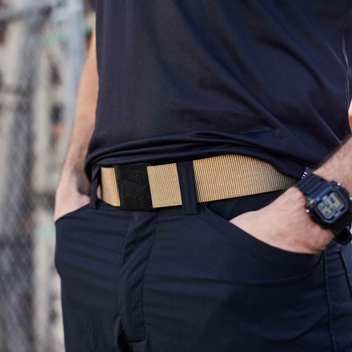 GORUCK tactical coyote belt worn with black pants and watch, outdoor setting