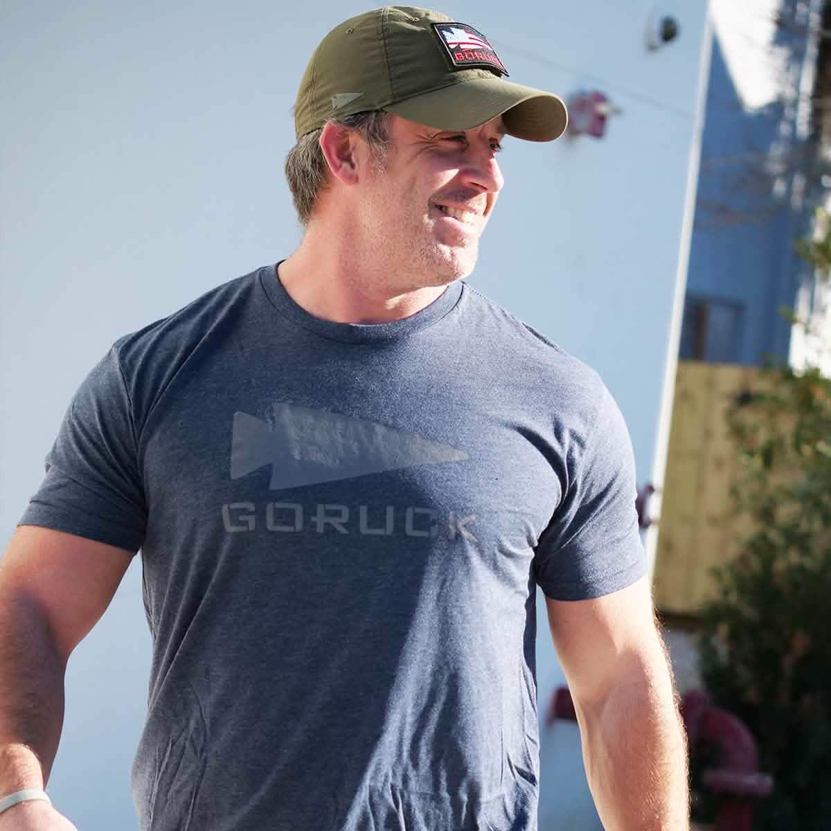 Man wearing GORUCK logo t-shirt and cap outside, rucking gear lifestyle photo