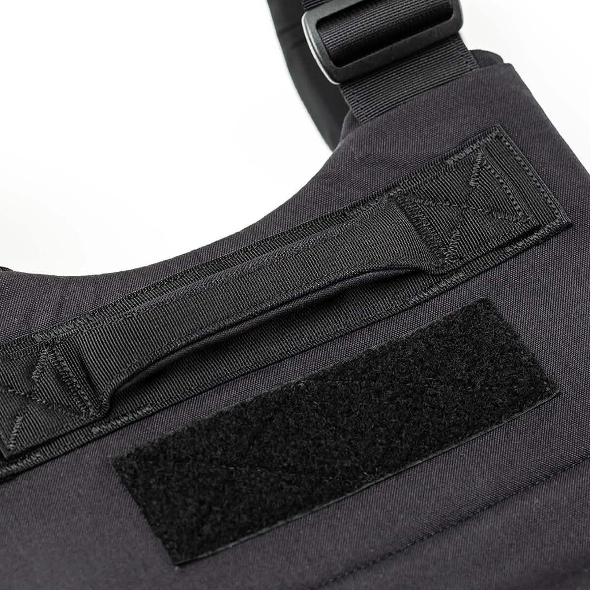 Close-up of the Training Weight Vest - Black, showcasing its sturdy handle and rectangular Velcro patch, with an adjustable fit for workouts.
